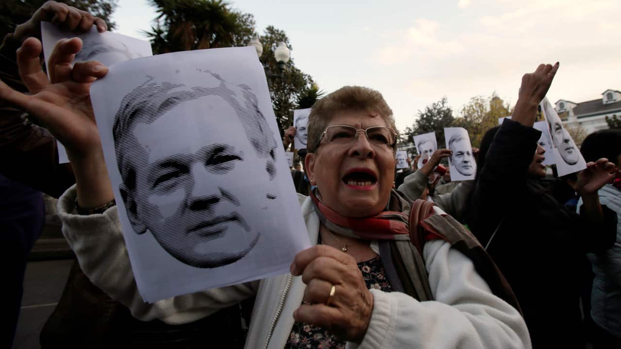 Ecuadoreans hold pictures of Julian Asssange during a demonstration to support him in front of Government Palace in Quito, Ecuador.