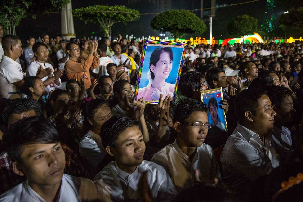 Myanmar citizens hold photos of Aung San Suu Kyi during an interfaith prayer ceremony organized by the National League for Democracy.