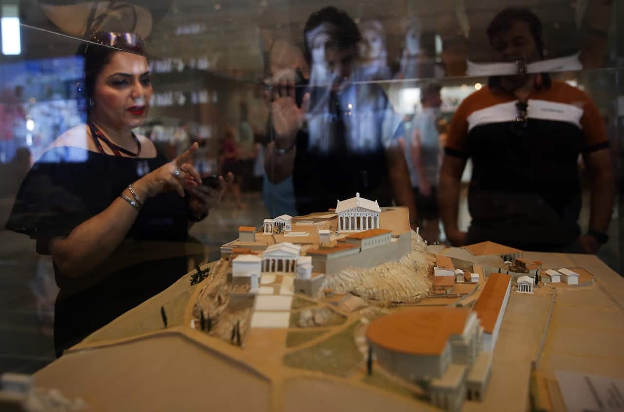 Tourists look at a maquette of the Acropolis Hill as they visit the Museum of Acropolis in Athens, Greece, 21 June 2019,