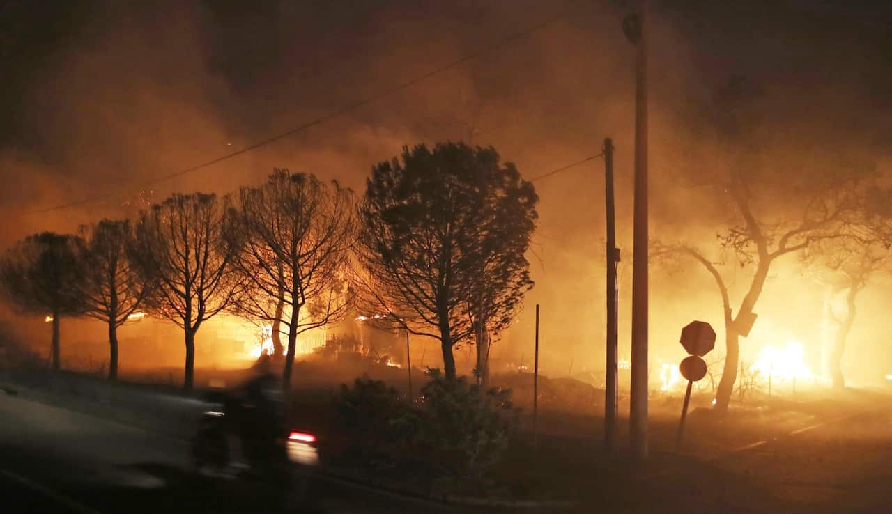 Buildings burn in the town of Mati, east of Athens, Monday, July 23, 2018. 