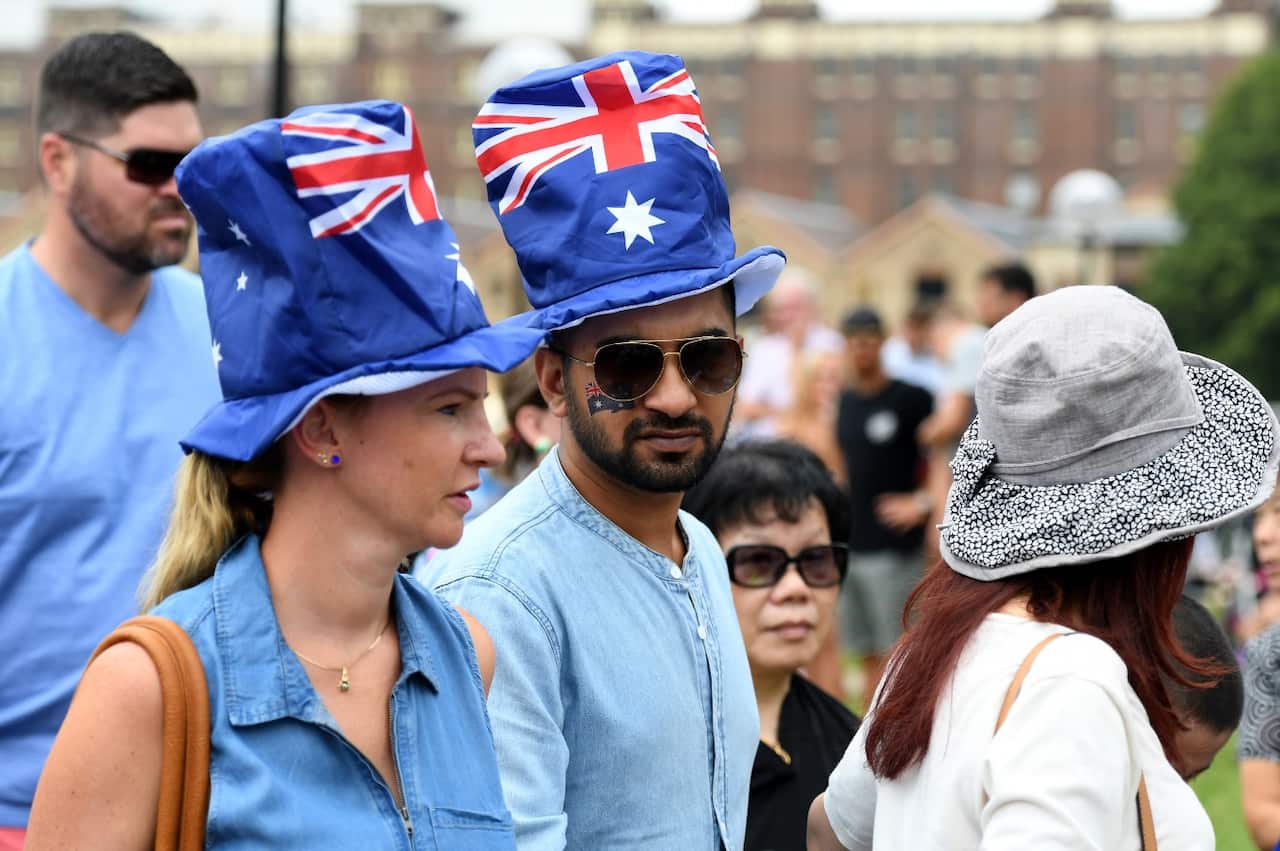People wearing Australian flag hats watch the Ferrython race on Sydney Harbour during Australia Day celebrations in in Sydney, Thursday, Jan. 26, 2017. (AAP)