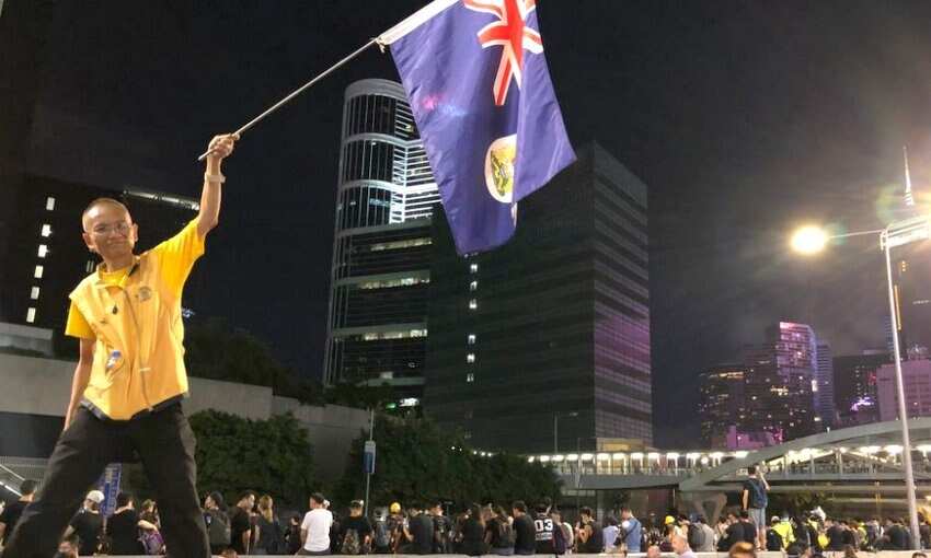 A man brandishes the most recognisable and final colonial flag of Hong Kong, as crowds amassed outside police headquarters in Admiralty.
