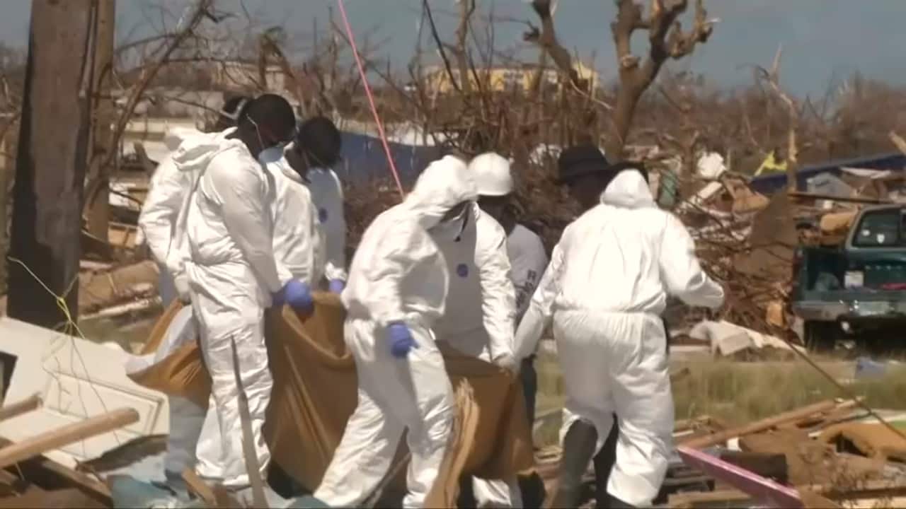 Rescue workers retrieve the body of a Hurricane Dorian victim. The devastating storm has left at least 45 people dead. 