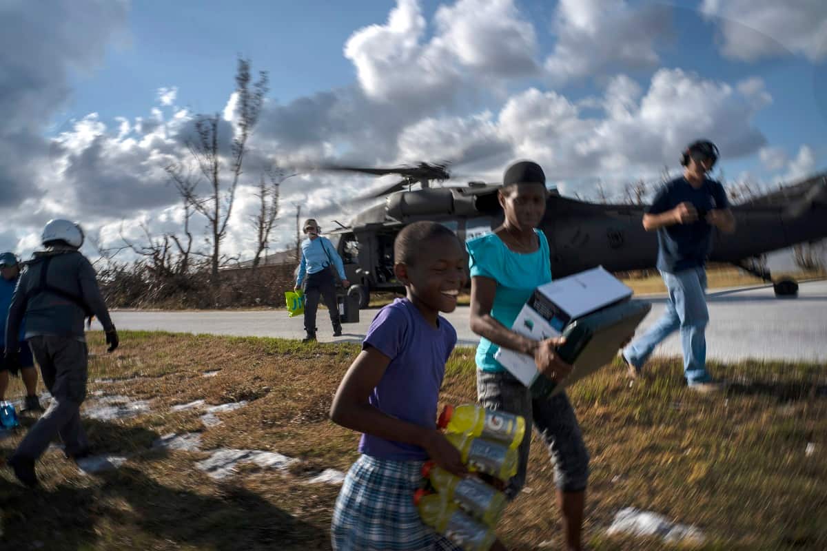 Ayfon Minus, 8, collects food taken by helicopter from the capital to the village destroyed by Hurricane Dorian In High Rock, Grand Bahama.