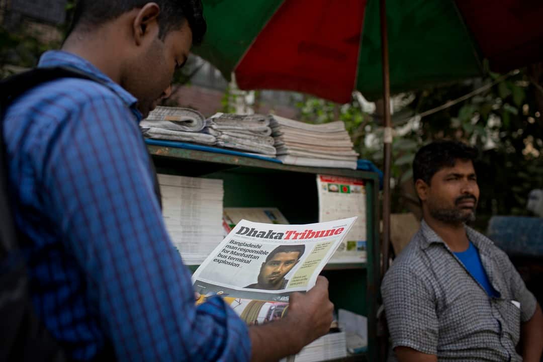 A Bangladeshi man reads a national newspaper running the news of 27-year-old Bangladeshi man Akayed Ullah on its front page.