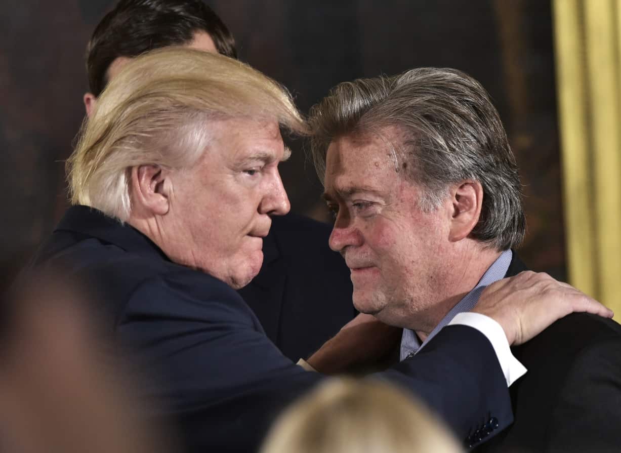 US President Donald Trump (L) congratulates Senior Counselor to the President Stephen Bannon during the swearing-in of senior staff in January 2017