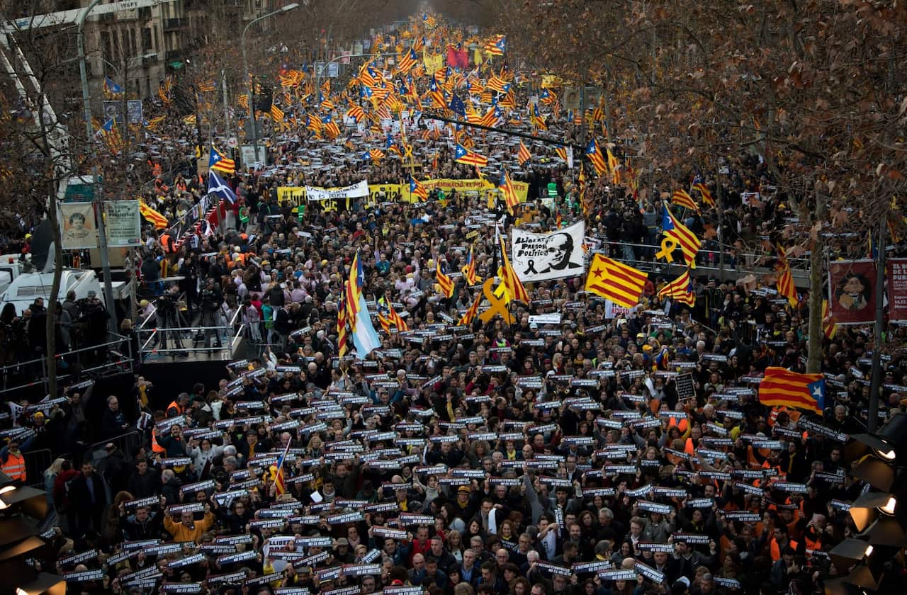 Pro independence demonstrators hold banners that says in Catalan "self-determination is not a crime".