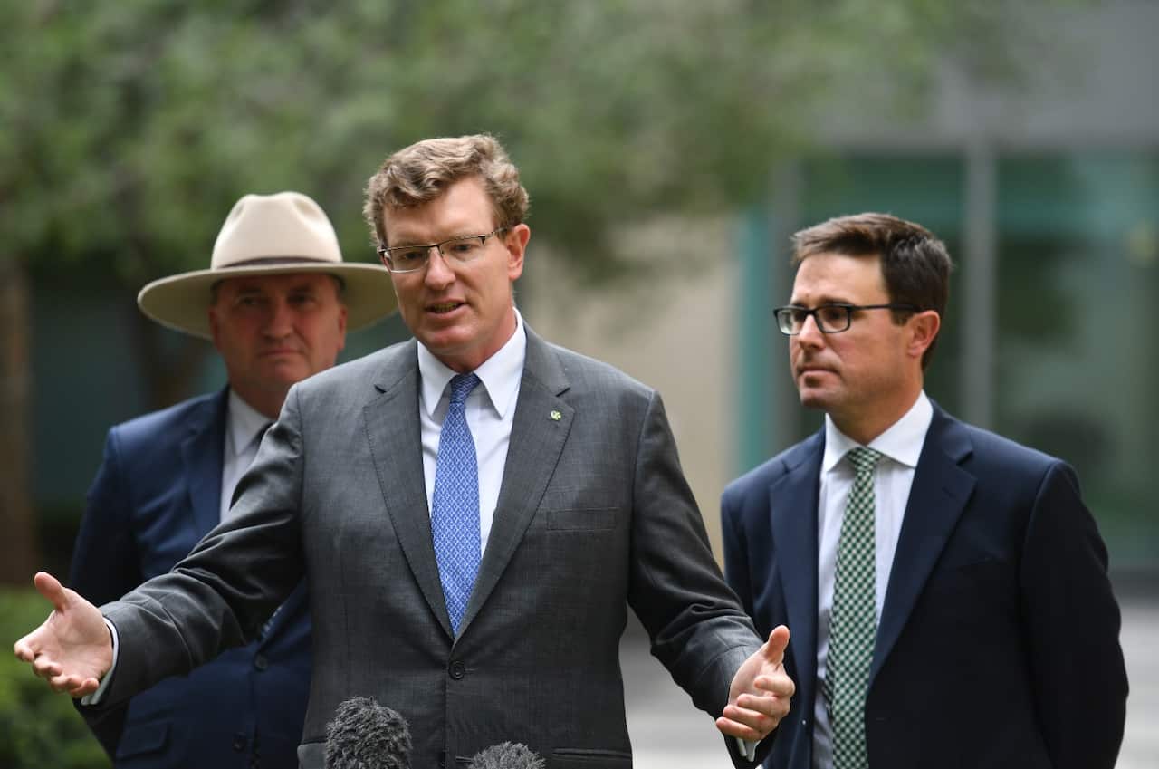 Three men wearing suits and ties standing outside