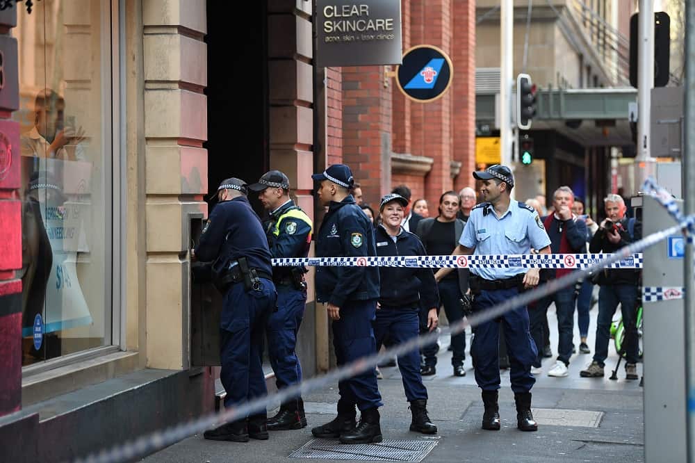 Police investigate the area around a crime scene after a man stabbed a woman and attempted to stab others in central Sydney on August 13, 2019.