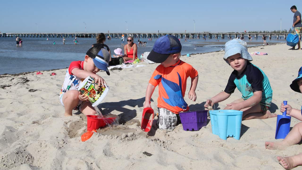 Kids play in the sand at Altona beach in Melbourne.