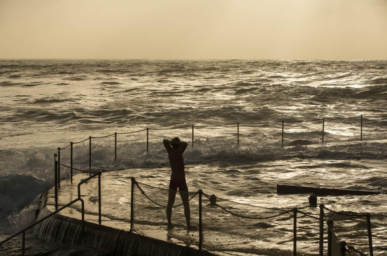 A swimmer looks on as strong winds create choppy seas at the Bronte Beach Ocean Pool in Sydney (AAP)