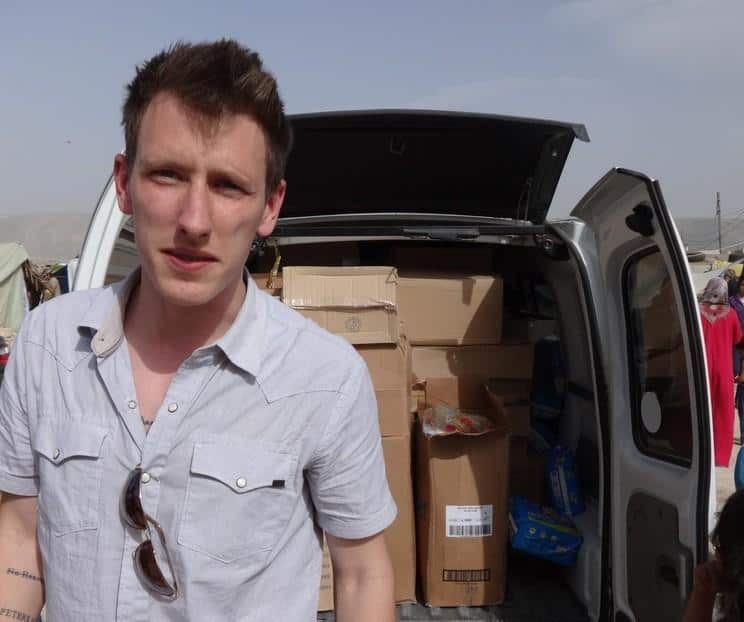 Peter Kassig standing in front of a truck filled with supplies for Syrian refugees.