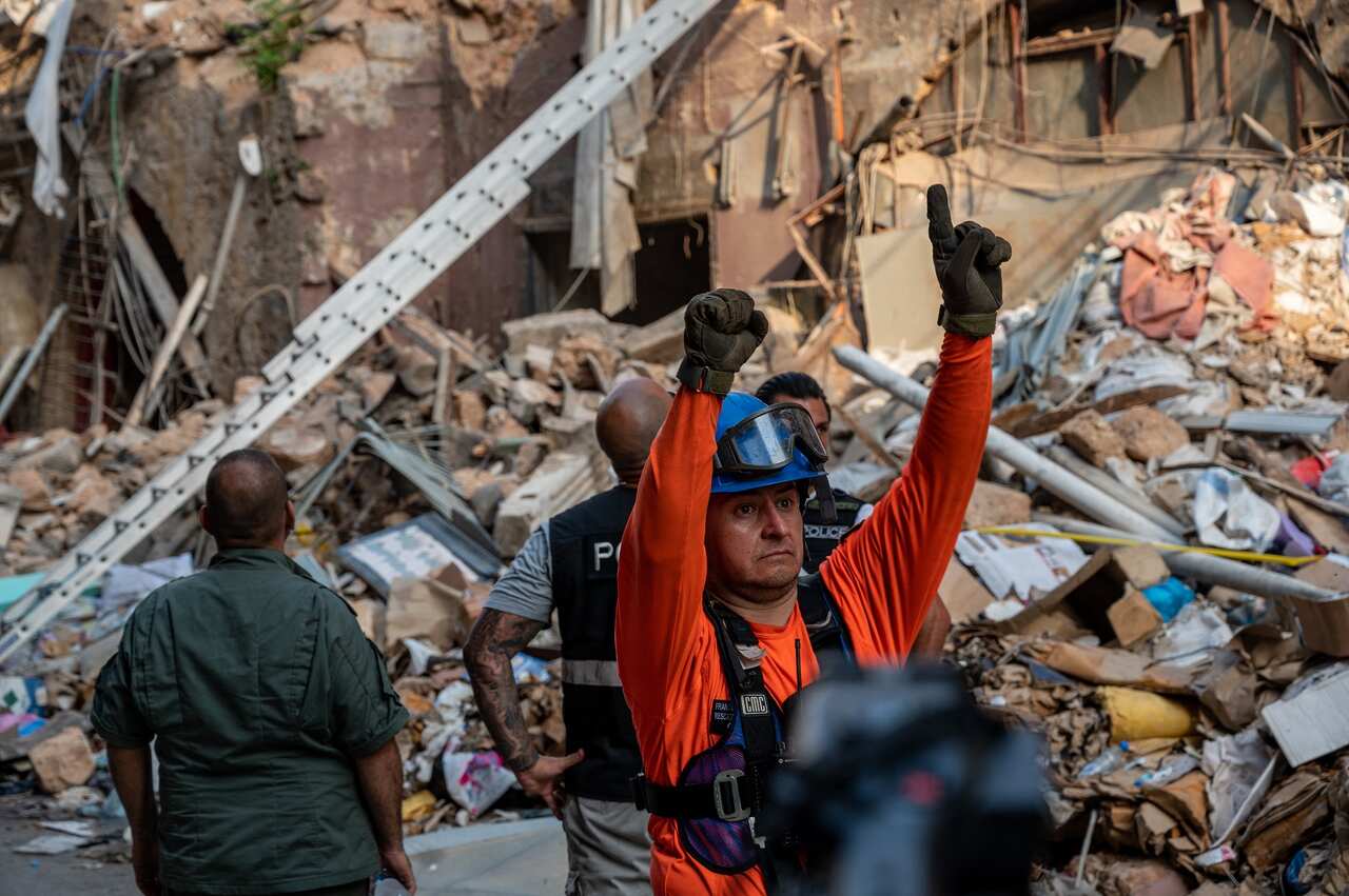 Chilean and Lebanese rescue workers search in the rubble of a building that collapsed in last month's explosion.