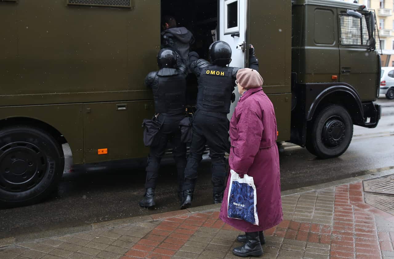 Police officers detain a protester during a rally
