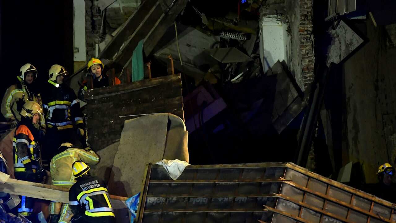 Firefighters inspect the collapsed building.