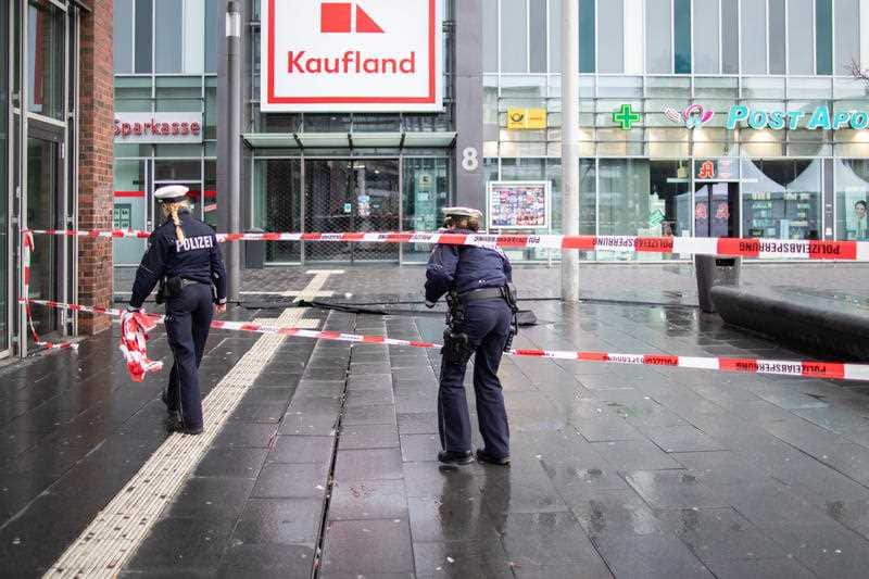 Police walk behind barrier tape on Berlin Square after a man had driven his car into a group of pedestrians and injured at least four.