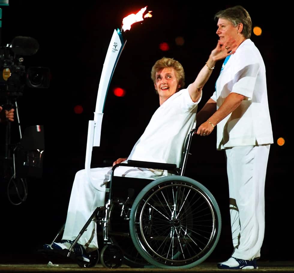 Raelene Boyle (R) and Cuthbert as they carry the Olympic torch at the end of the opening ceremony of the Olympics Friday, Sept. 15, 2000 (AAP)