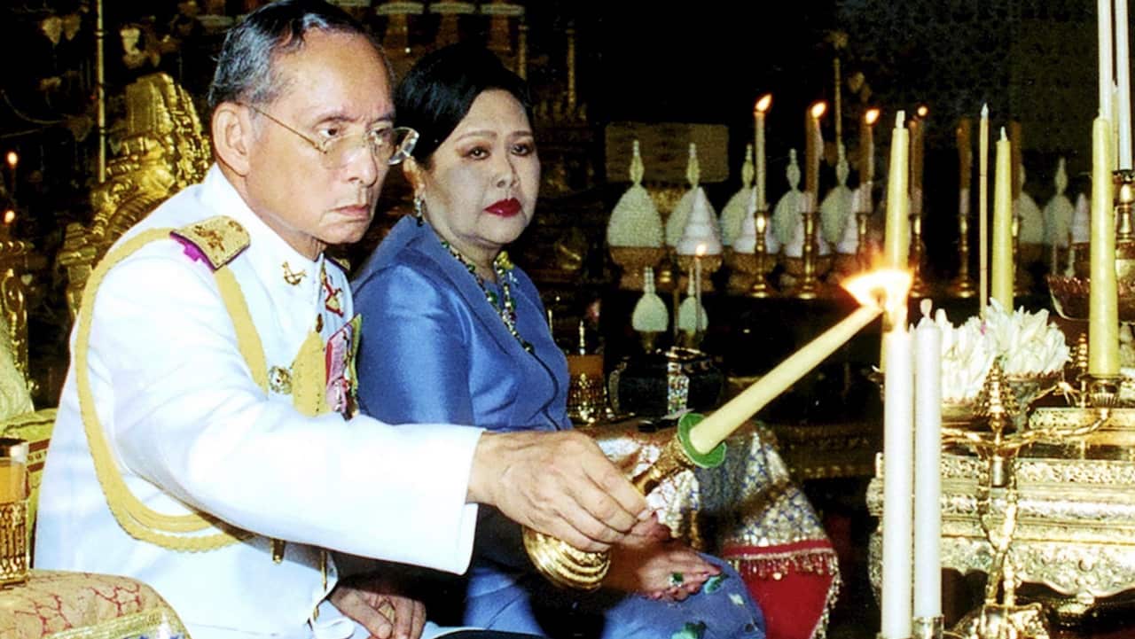 Thai King Bhumibol Adulyadej lights a candle with Thai Queen Sirikit by his side, in the Royal Grand Palace in Bangkok on 3 May 2006. 