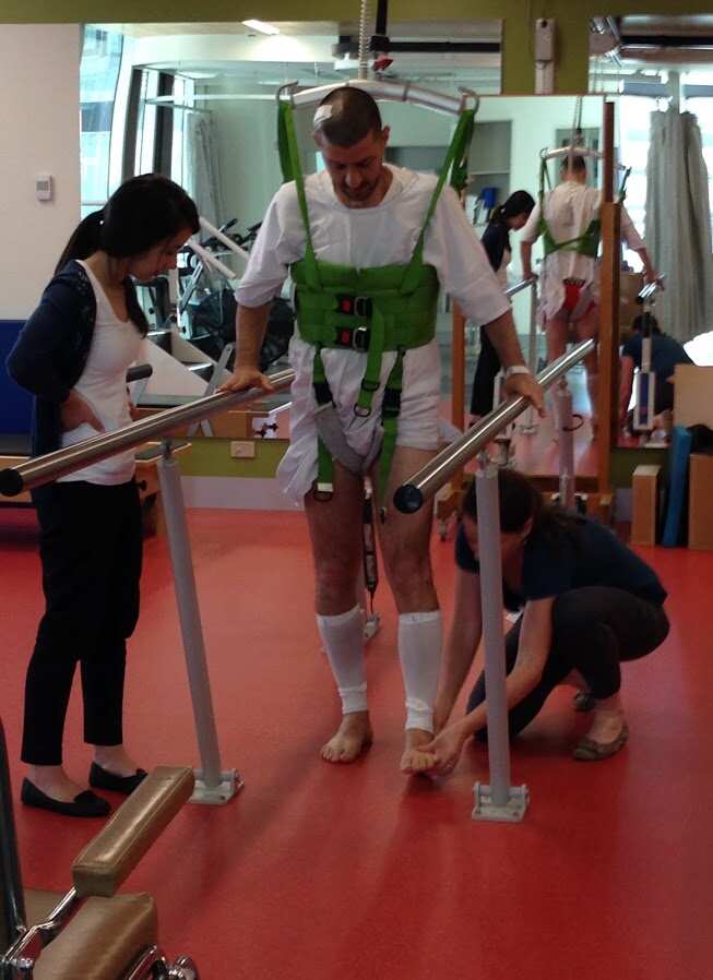 Bill Gasiamis learns to walk with supporting rails.