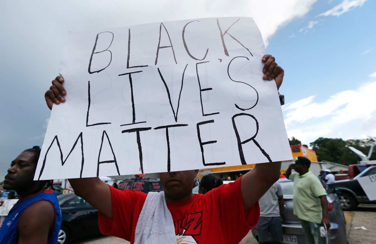 Demonstrators encourage passing motorists to honk outside the Triple S convenience store in Baton Rouge, La (AAP)