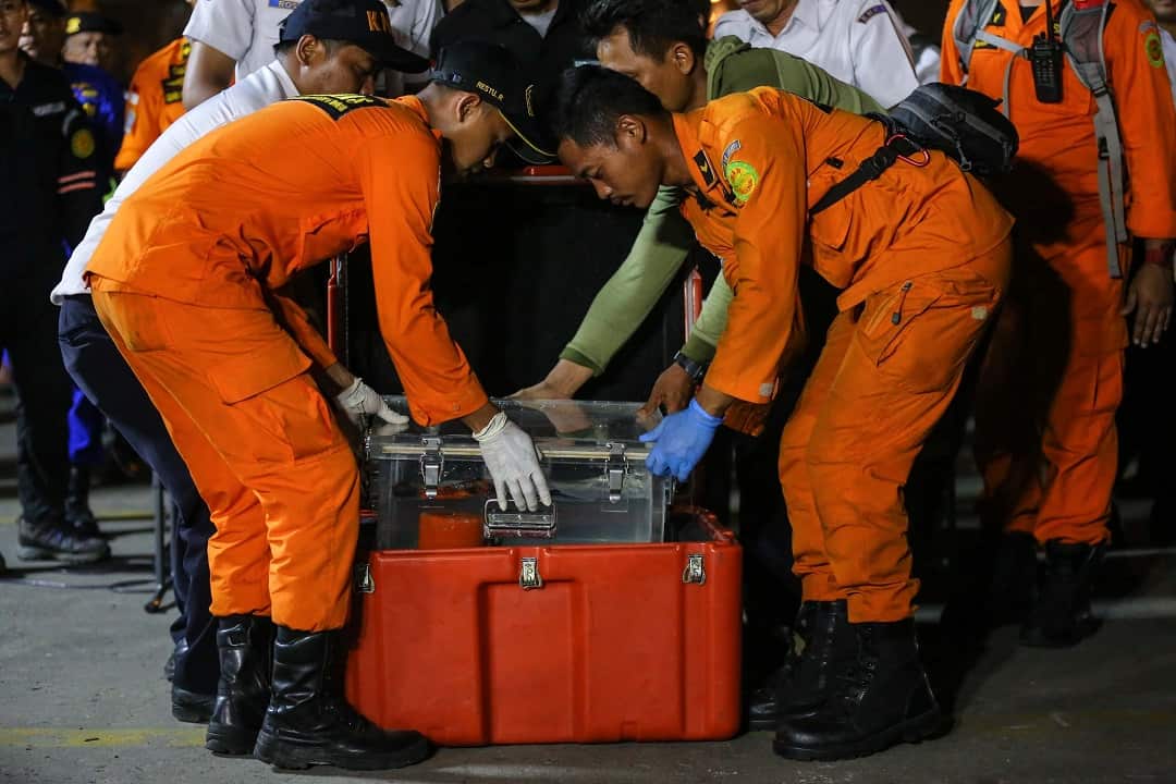 Searchers pack away the black box, which was found about 400 meters from the aircraft's last recorded position.