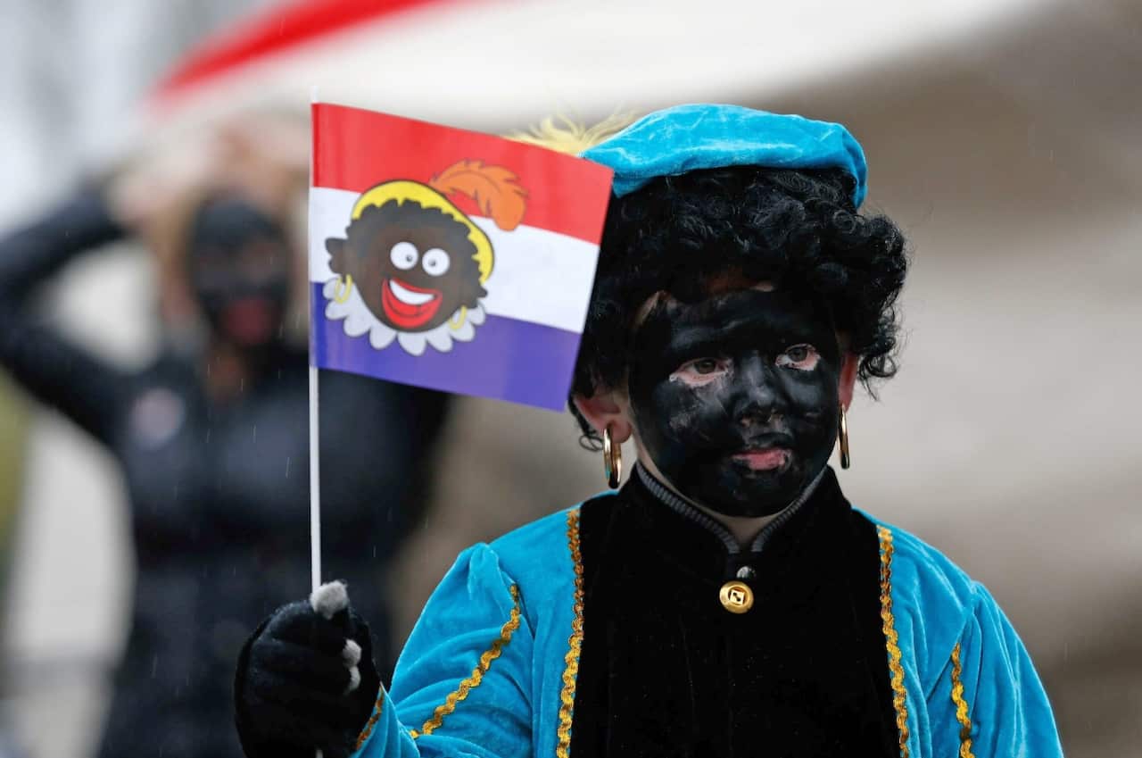 A child dressed as 'Zwarte Piet' or Black Pete (entirely black painted face) walks in Gouda, The Netherlands, 15 November 2014