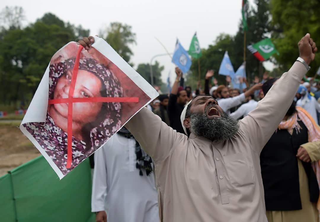 A Pakistani supporter of a hardline religious party, holds an image of Christian woman Asia Bibi during a protest rally.