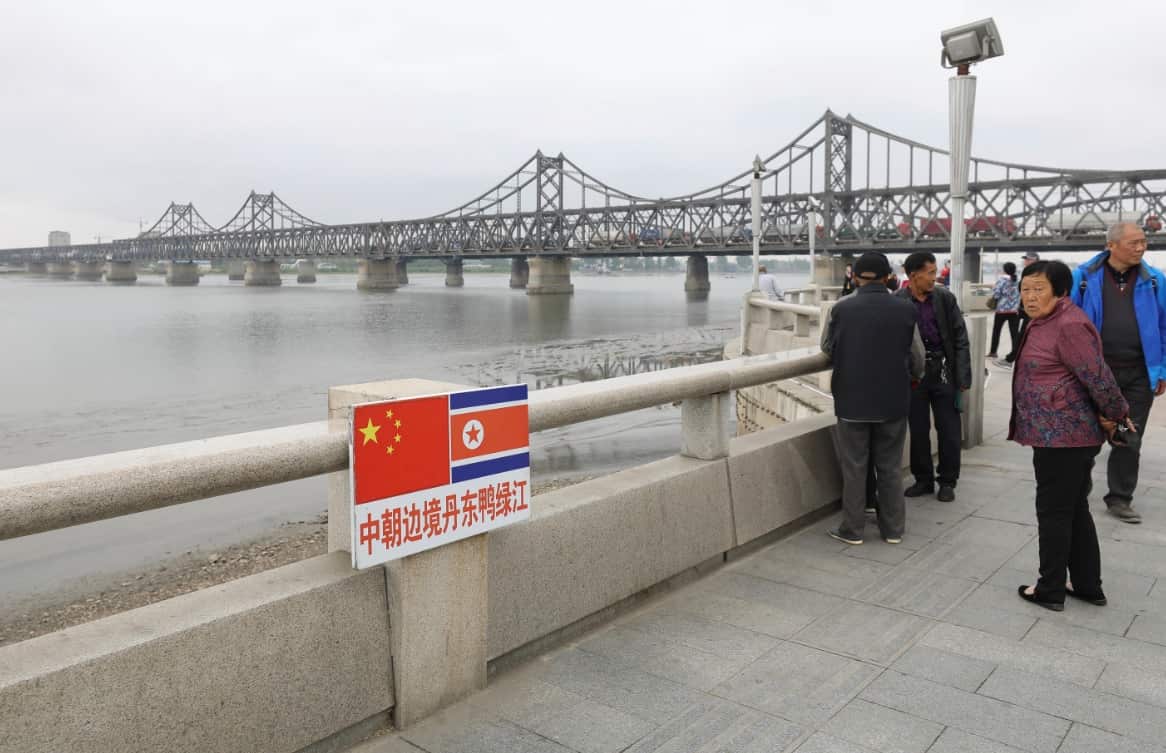 Tourists pose for photos along the Yalu River, also called the Amrok River or Amnok River, on the border of China and North Korea in Dandong city