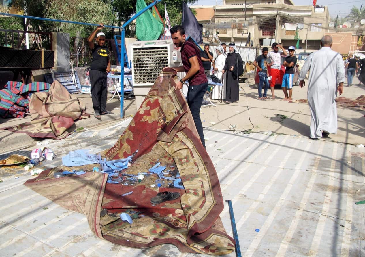 Iraqis inspect the site of a suicide bomb attack that targeted a funeral tent in Shaab district, Baghdad, Iraq, 15 October 2016. (AAP)