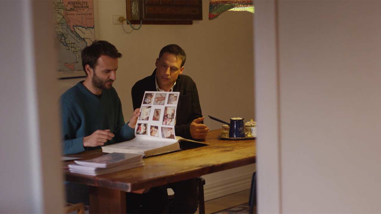 Damir and David in Melbourne looking through photos from Damir's childhood in Bosnia.