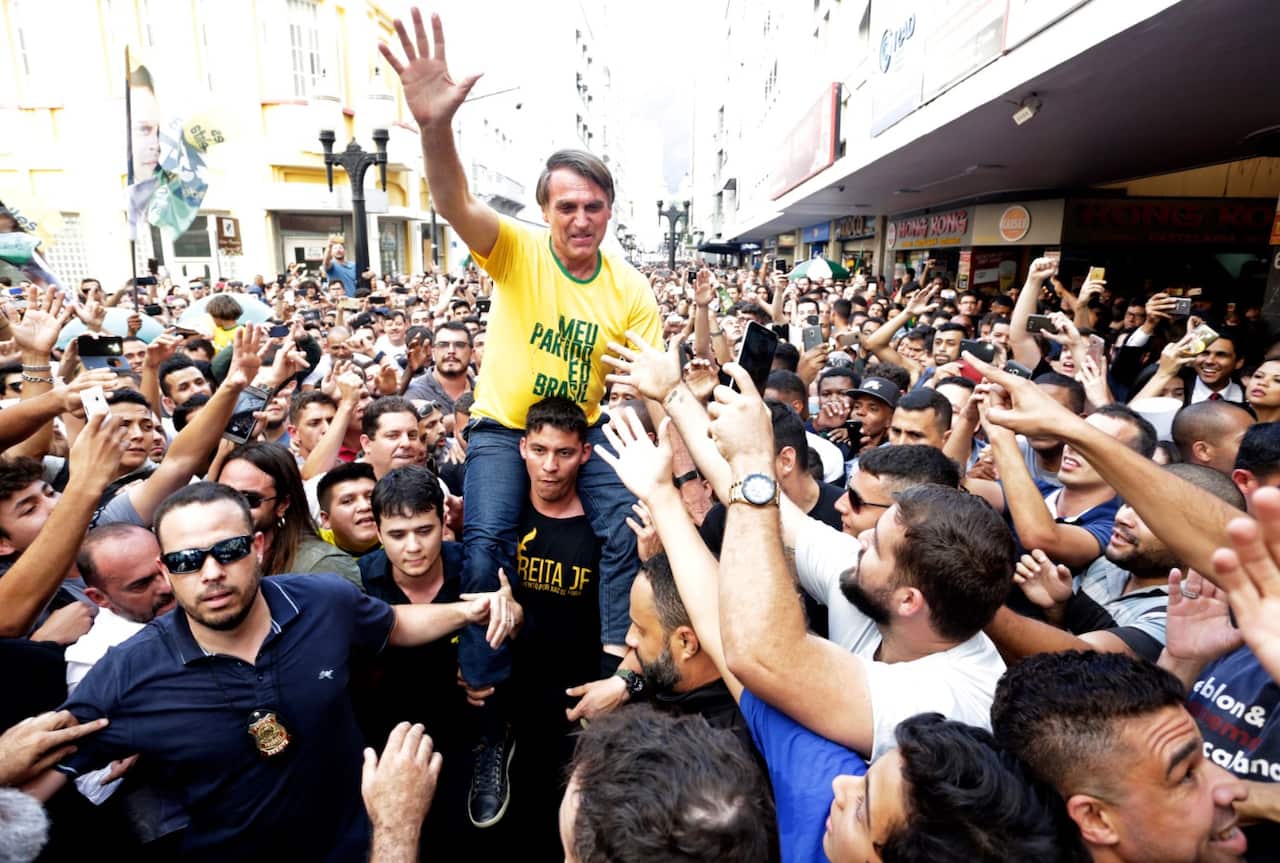 Presidential candidate Jair Bolsonaro is taken on the shoulders of a supporter moments before being stabbed during a campaign rally in Juiz de Fora, Brazil
