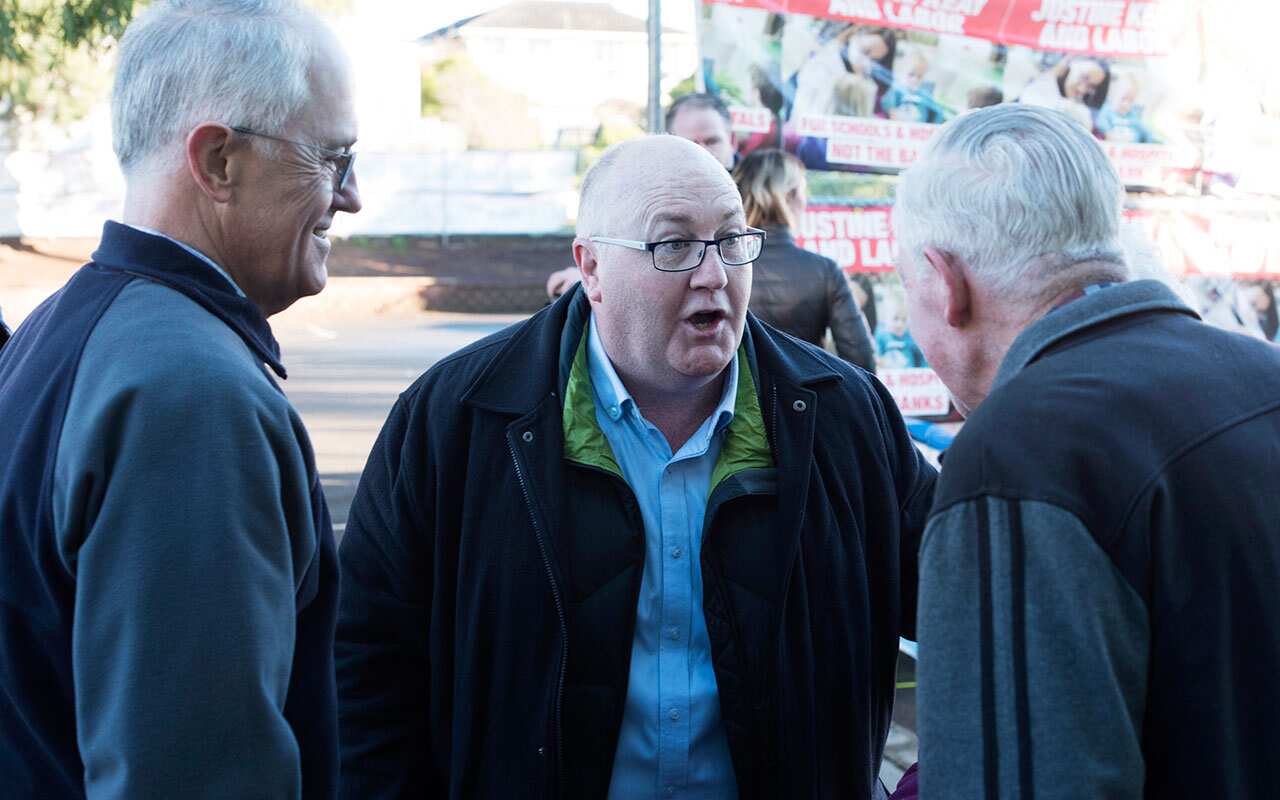 Prime Minister Malcolm Turnbull and Liberal candidate Brett Whiteley (centre) are seen talking to a voter at Nixon Street Public School, Devonport, Tasmania