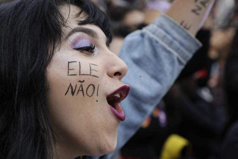 A woman with the words "Not him" written on her face, takes part in a protest against Jair Bolsonaro, the presidential front-runner.