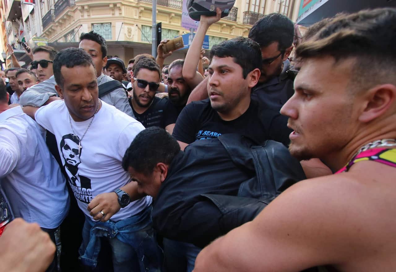 A handout photo made available by Tribuna de Minas shows A group of people try to detain Adelio Bispo de Oliveira (c-down)