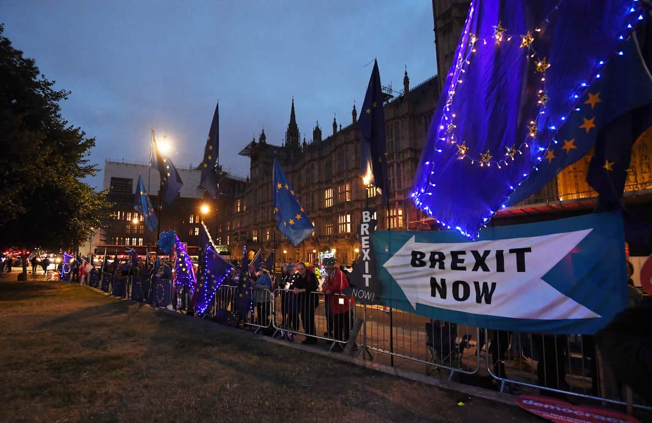 Anti and pro Brexit protesters stand outside the Houses of Parliament in London.