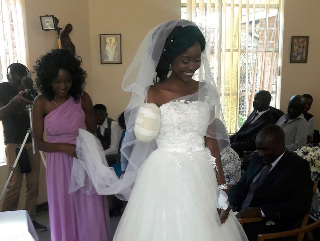 In this photo taken on Saturday, May, 5, 2018, Zenele Ndlovu walks down the aisle on her wedding day at a hospital Chapel in Bulawayo, Zimbabwe.