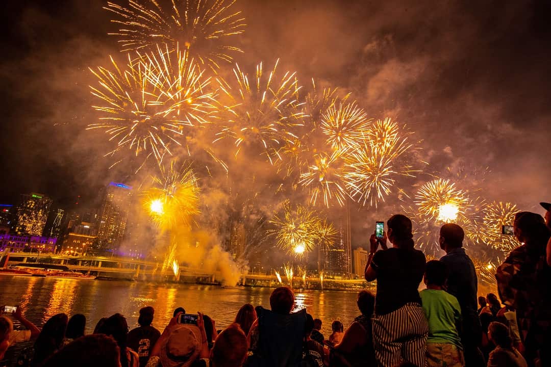 People in Brisbane watch the New Year's Eve fireworks by the Brisbane River at Southbank.