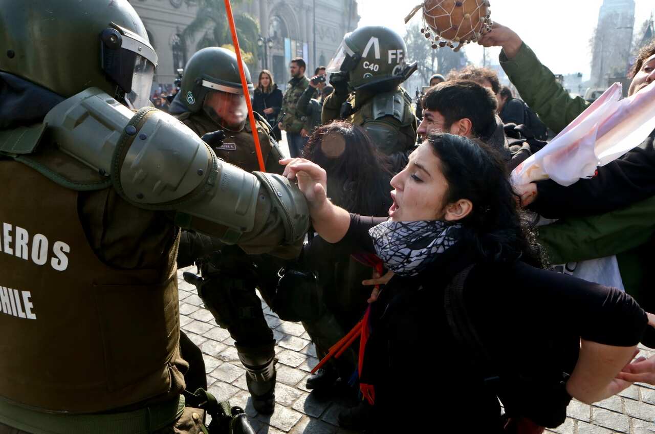 People protesting against of the self-proclaimed "Bus of freedom," which rejects transgender children in schools, clashes with police in downtown Santiago (AAP)