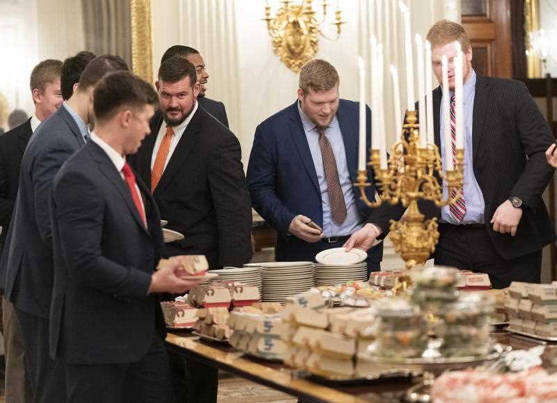 Guests attending a reception for the Clemson Tigers grab fast food sandwiches in the State Dining Room of the White House.