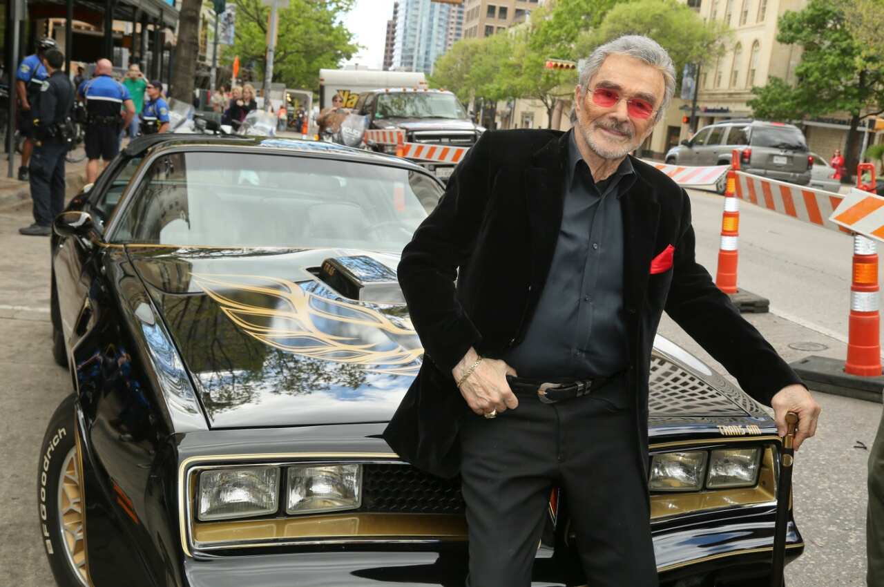 Burt Reynolds sits on a 1977 Pontiac Trans-Am at the world premiere of "The Bandit" at the Paramount Theatre in 2016
