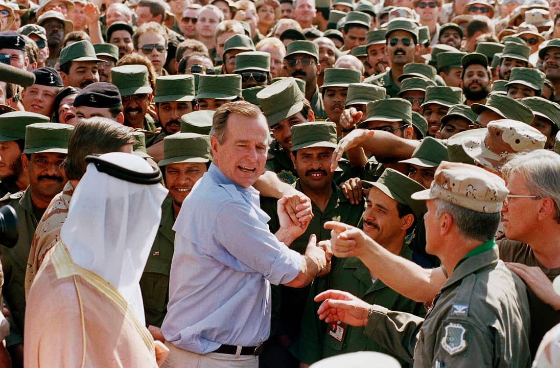 1990: President George Bush is greeted by Saudi troops and others as he arrives in Dhahran, Saudi Arabia, for a Thanksgiving visit.