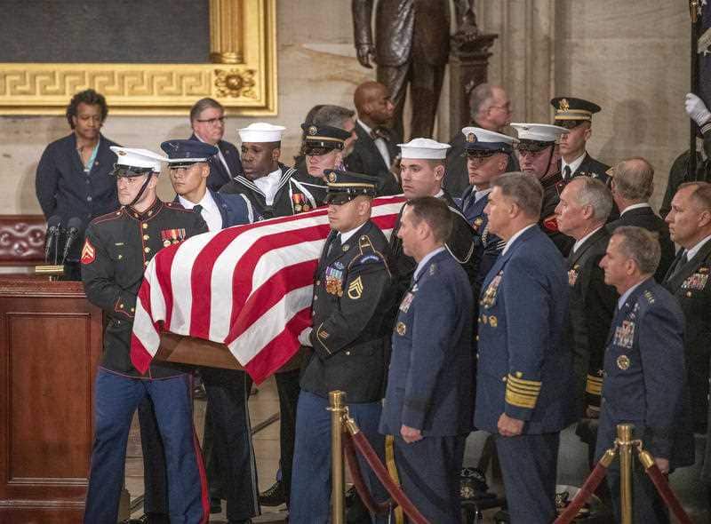 A military honour guard carries the former president's coffin.