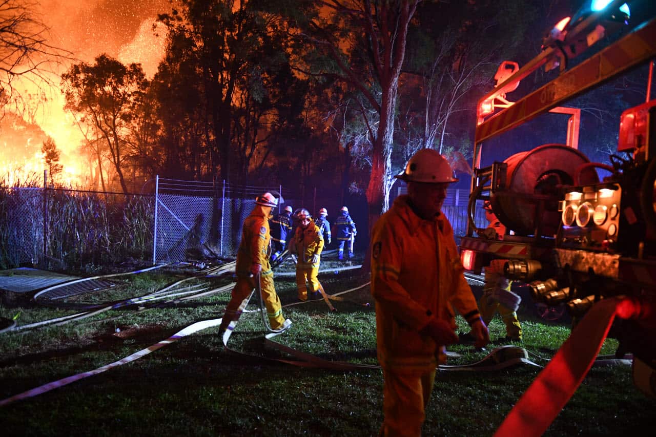 Firefighters fight flames close to homes in Corryton Court, Wattle Grove in Sydney, Saturday, April 14, 2018. 