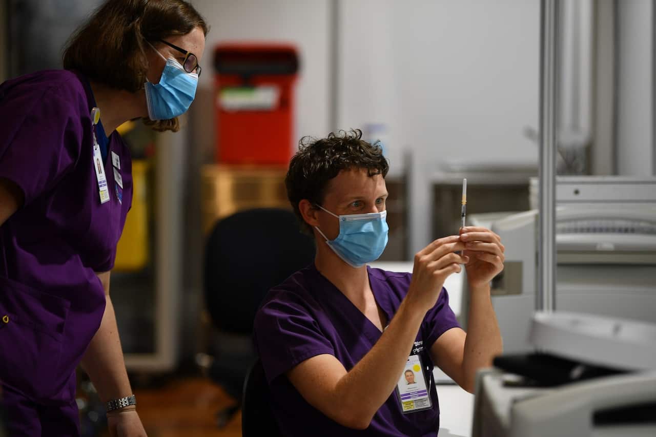 A healthcare worker is seen handling an AstraZeneca Covid-19 vaccination inside a vaccination centre. 