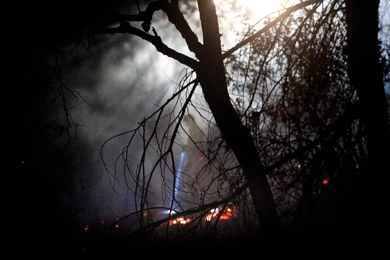 An firefighter traverses a hillside while battling the Kincade Fire near Windsor, California.