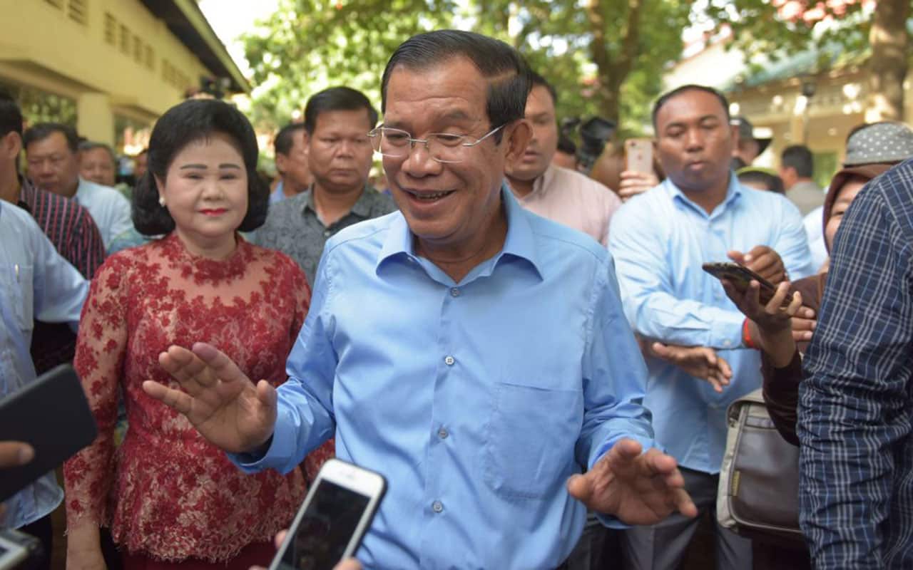 Cambodia's Prime Minister Hun Sen (C) and his wife Bun Rany (L) after casting their votes in the general election.