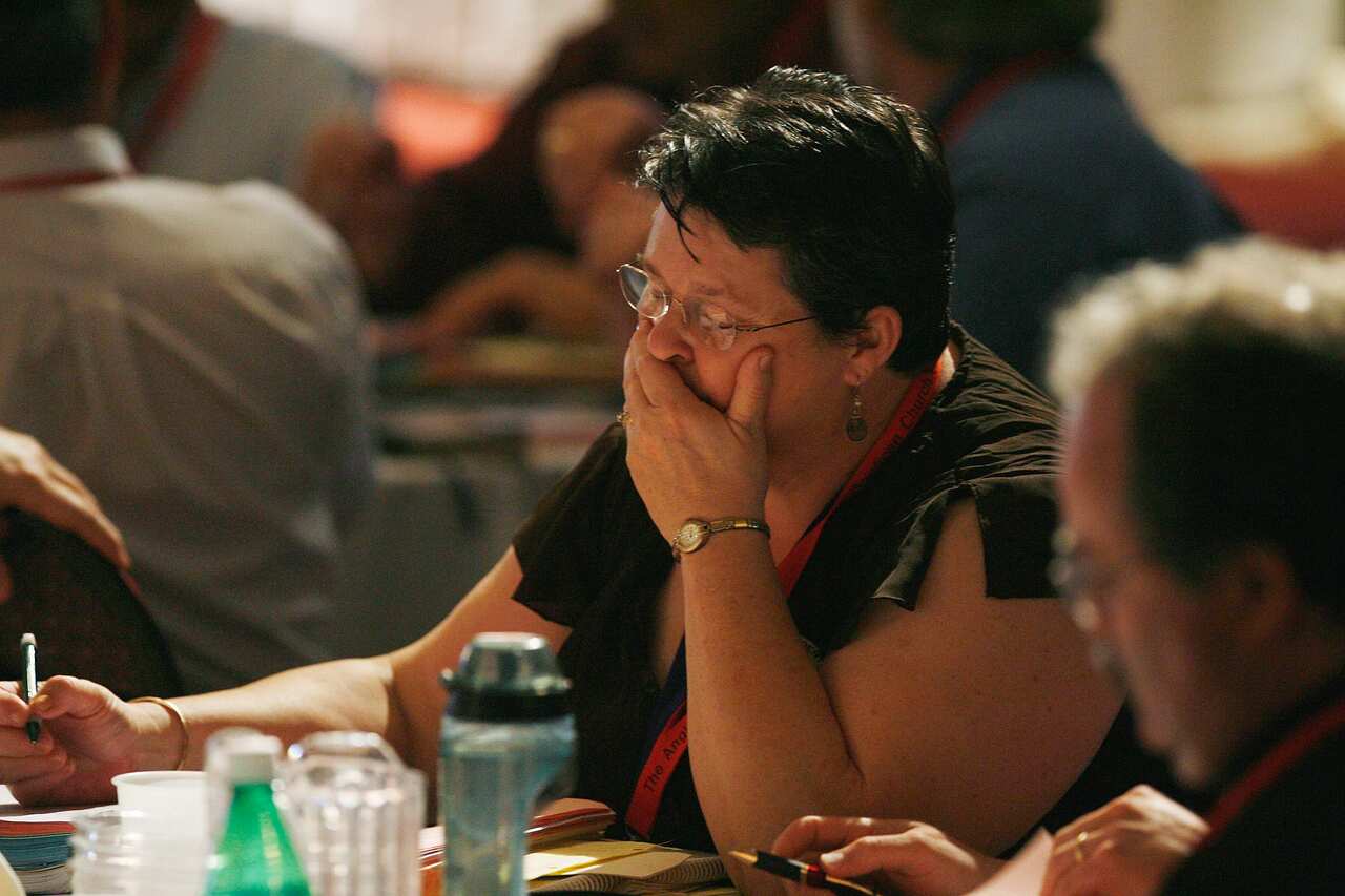 An Anglican church delegate reacts after the results are announced.