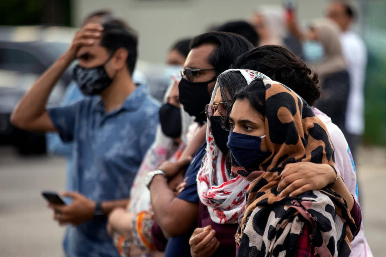 People attend a vigil for the four family members who were killed in a vehicle attack that police say was motivated by anti-Muslim hate.