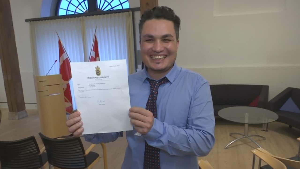 Afghan-born Skander Khan holding up proof of citizenship. 