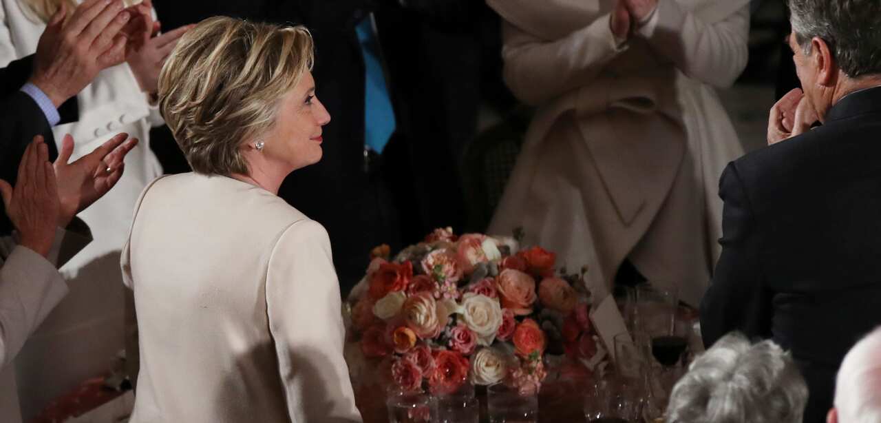 Hillary Clinton was seated at a table with her husband, President Bill Clinton, and House Minority Leader Nancy Pelosi. 